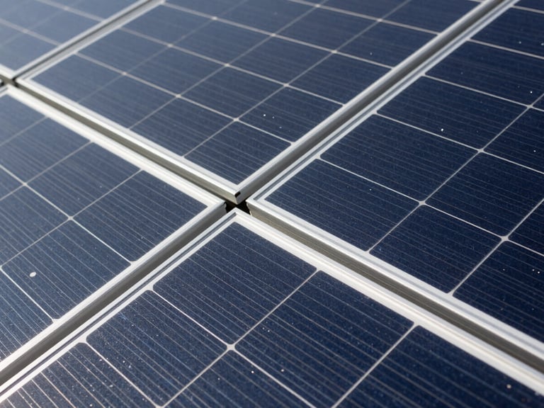 Close-up of a solar panel array, showing technical details and connections, under bright daylight. Industrial editorial photography, clean technical details, high contrast, deep slate and steel tones, 35mm.