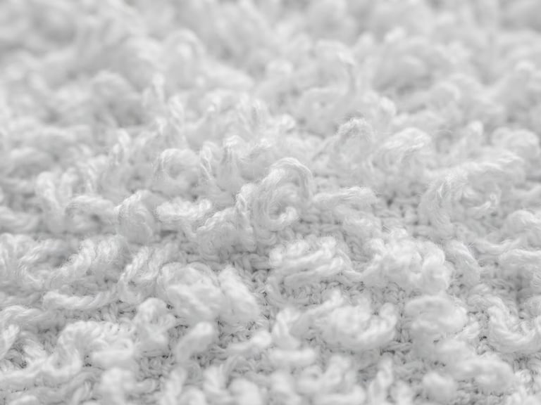 Macro detail of high-density white terry towel loops, bright neutral daylight, crisp textile texture, professional B2B commercial photography.