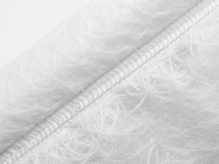 Macro close-up of a protective garment seam under bright sterile laboratory lighting, showing the precise ultrasonic welding and dense non-woven fibers, high detail, 50mm lens