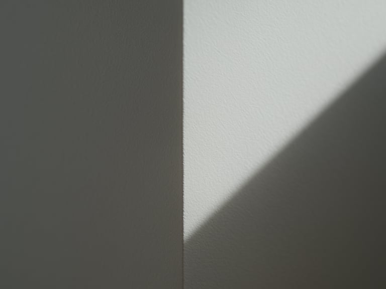 Close-up macro shot of a perfectly smooth, white drywall corner, crisp geometric shadow lines, flawless Q4 surface finish under sharp side lighting.