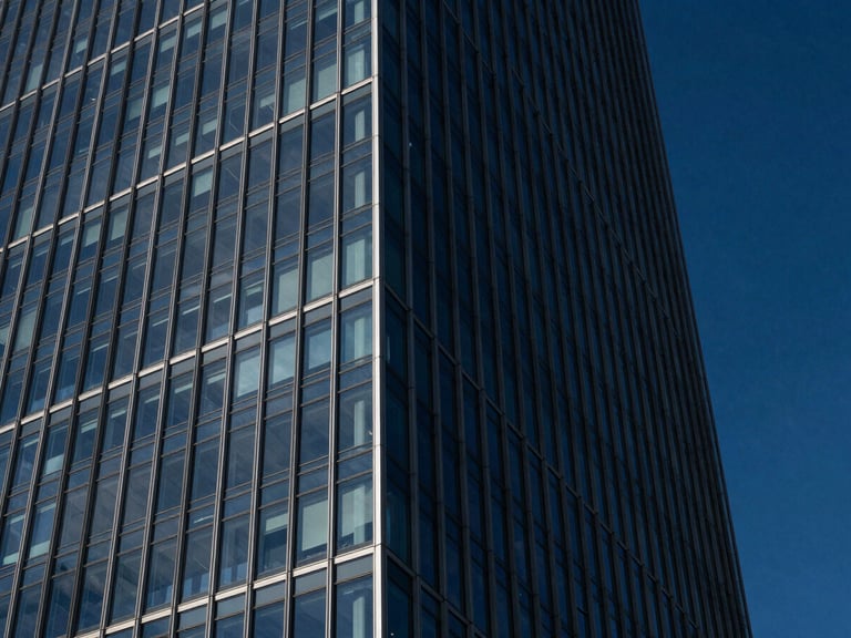 Dramatic architectural photography of a modern glass skyscraper corner reflecting deep midnight blue sky, sharp diagonal lines, high contrast.