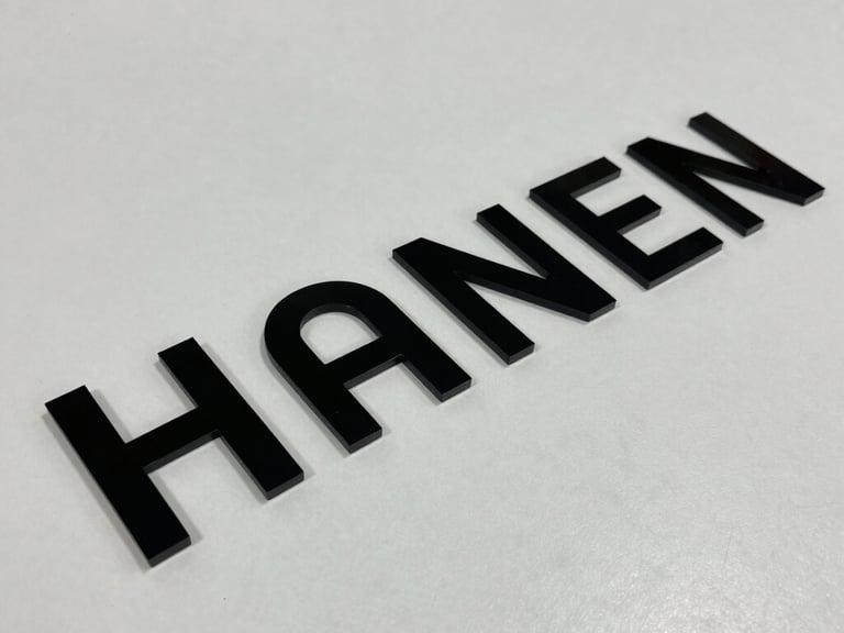 A precision CNC laser cutting machine carving an intricate geometric pattern into a light wood panel with sparks.
