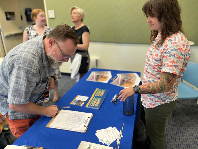 Rikki tabling and providing information to a man picking up literature