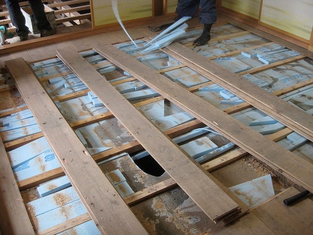 a man standing in a room with a flooring board