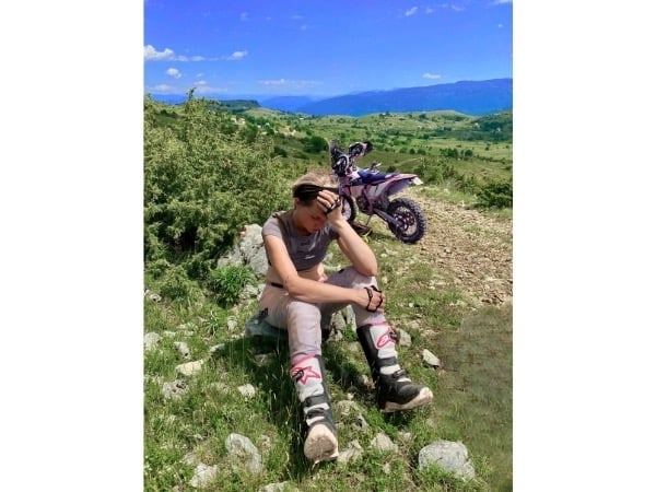 Yogalehrerin-Anja-sitzt-erschöpft-neben-dem-Enduromotorrad