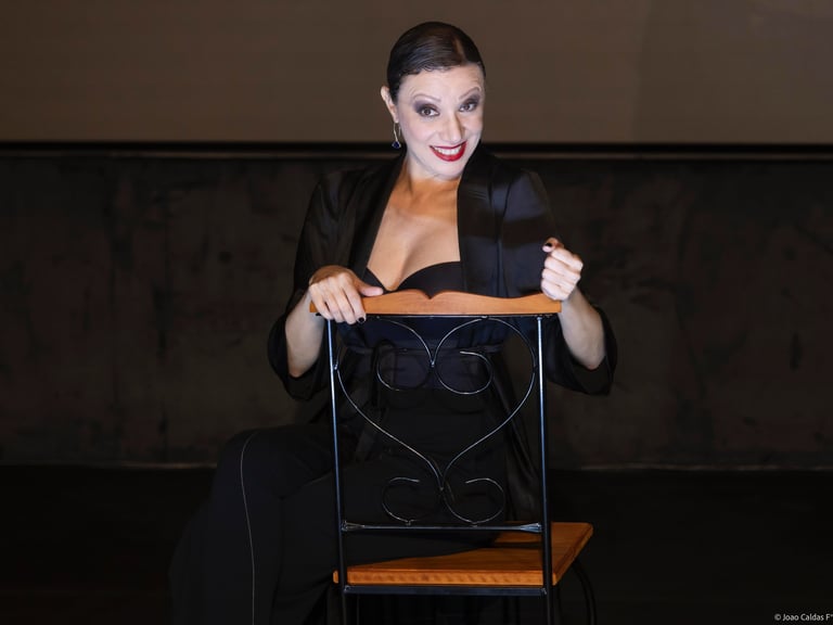 a woman in a black dress sitting on a chair