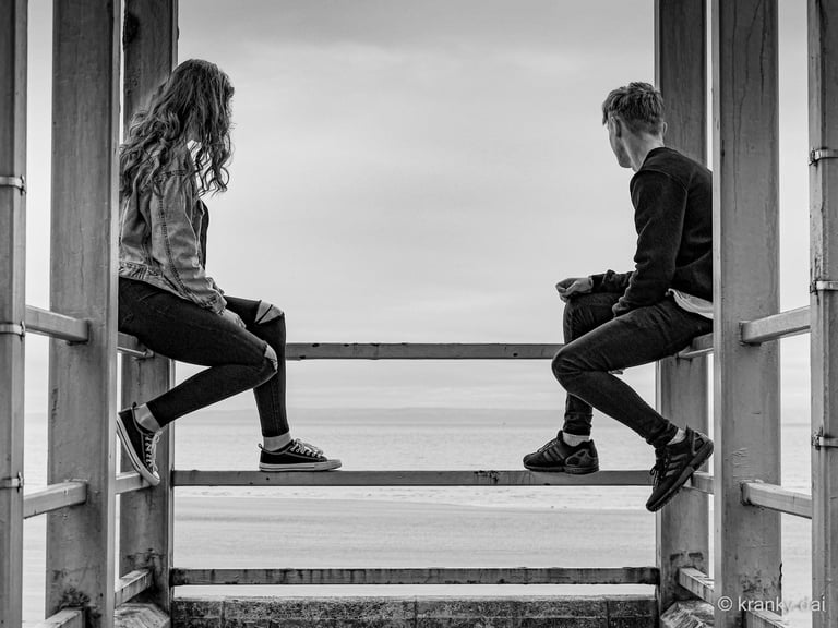 a man and woman sitting on a bench in a doorway