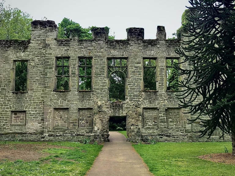 a large historical stone building with a walkway