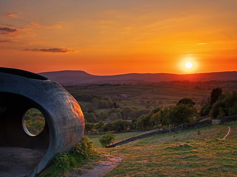 a sunset over a hill with a large circular shape: the wycoller atomd object