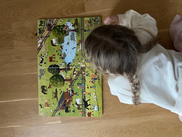 Ponytante - Kind schaut in das Wimmelbuch Pferde und Ponys