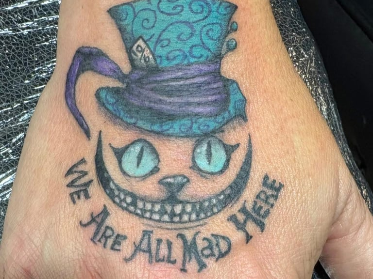 a tattoo of a mad hatter's cat with a mad hat on it