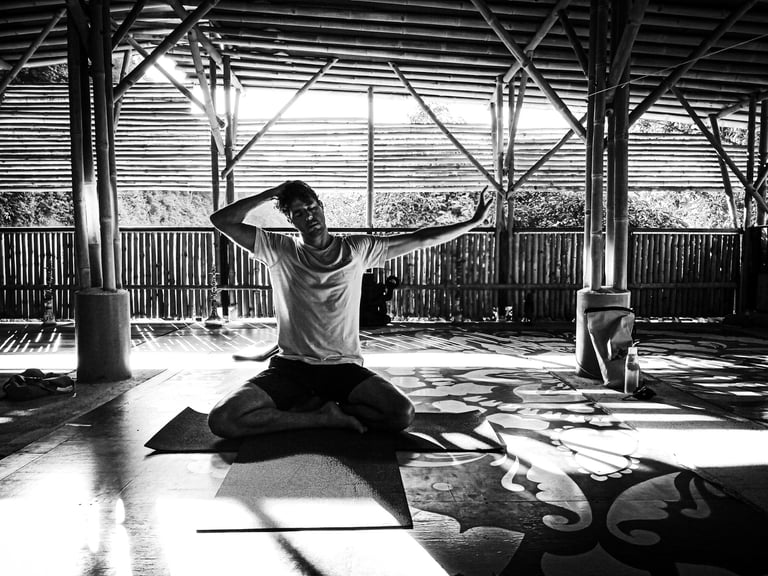 A man practices gentle neck stretches during yoga practice.