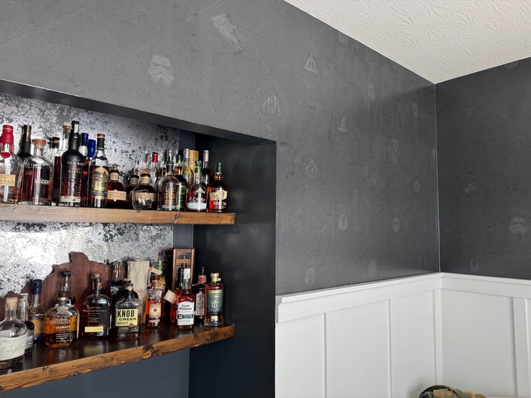 Modern home bourbon shelf and bar with dark textured custom wallpaper and wooden floating shelves
