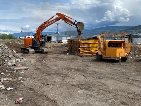 a construction site with an excavator and an incinerator 
