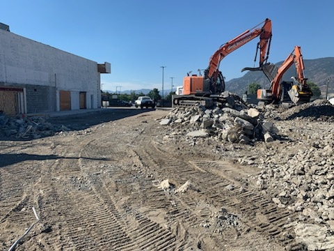 a construction site with two excavators crushing concrete