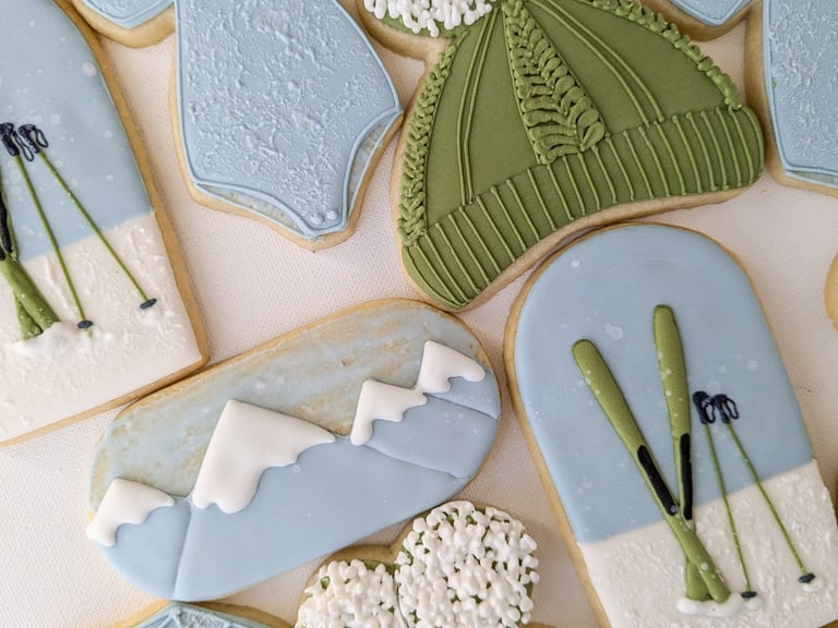 Cookies of onesies, hats, skis, and mountains for a baby shower