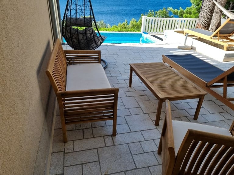 The photo shows a club set, deck chairs and an unobstructed view of the sea.