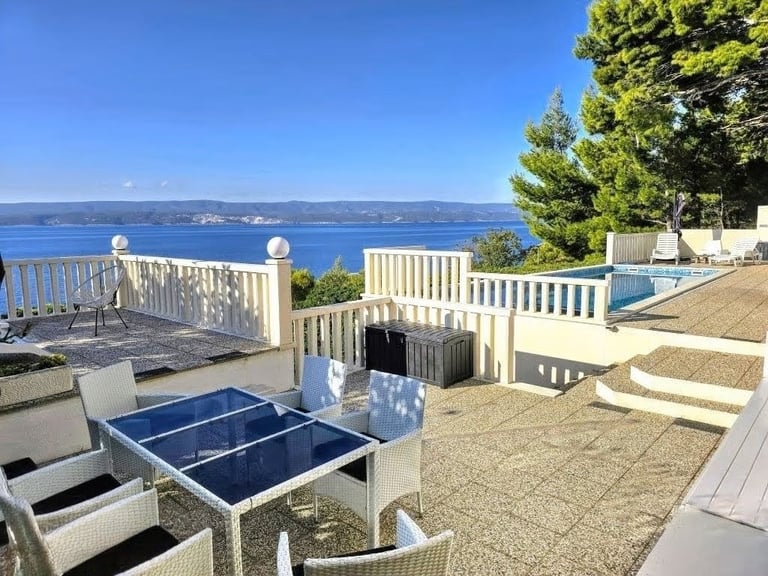 The photo depicts the courtard dining set as well as parts of the eastern sun terrace and pool.