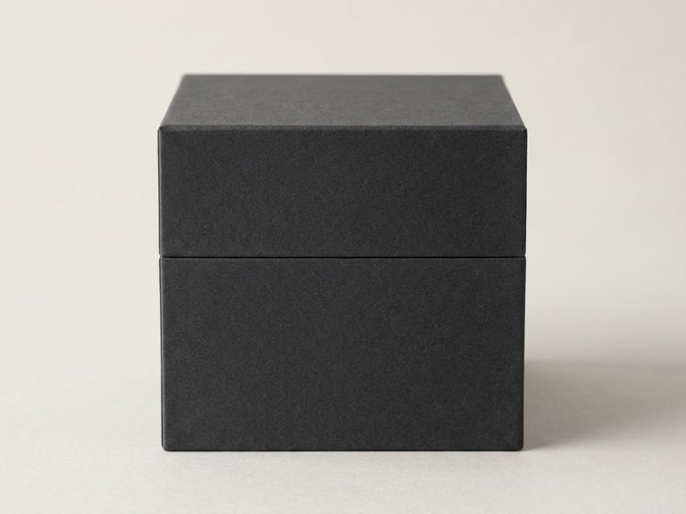 Pristine empty rigid cosmetic box with sharp 90-degree edges and matte charcoal texture, soft diffused studio lighting, neutral minimalist background, 85mm