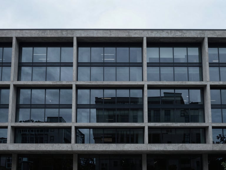 Architectural wide angle of a modern minimalist concrete and glass office facade, cool diffused daylight, desaturated navy tones.