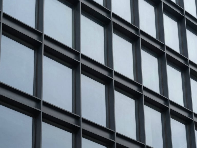 Tight abstract close-up of architectural steel and glass facade under cool overcast light, desaturated navy tones, sharp focus, 35mm lens.
