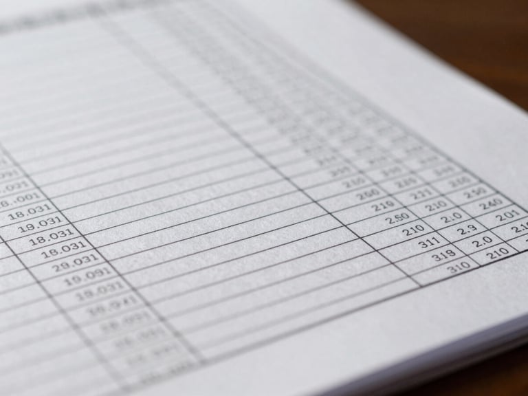 Macro close-up of structured financial ledgers and precise document lines under soft, professional office lighting.