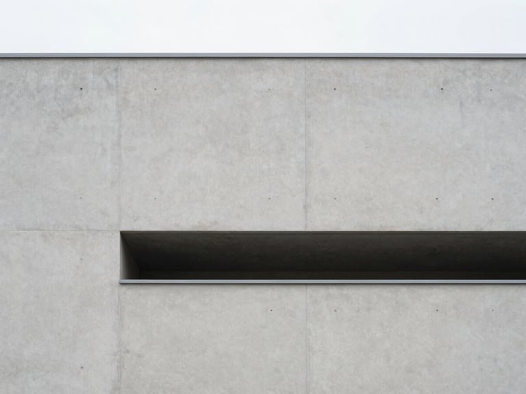 Minimalist architectural photography of a modern concrete building facade, soft diffused overcast daylight, clean structural lines, light gray and slate tones, 35mm