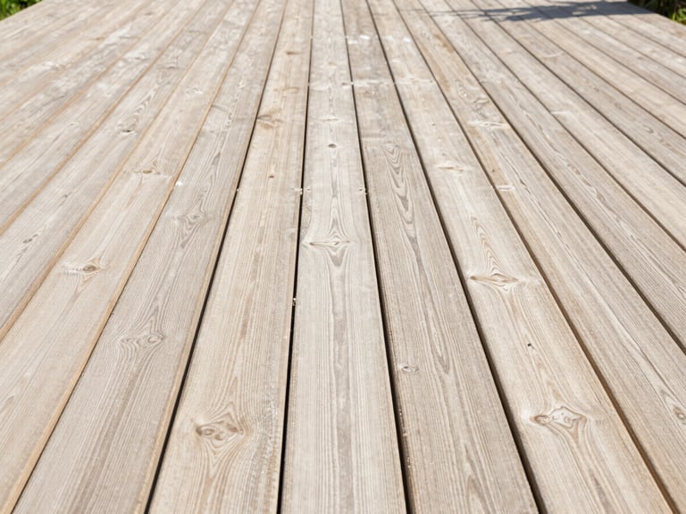 Wide environmental shot of a restored wooden garden decking area, clean natural wood grain visible, bright natural daylight, 35mm lens