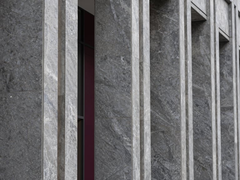 Tight abstract macro shot of premium grey marble and steel architectural columns in a modern financial headquarters lobby, sharp focus, crisp daylight