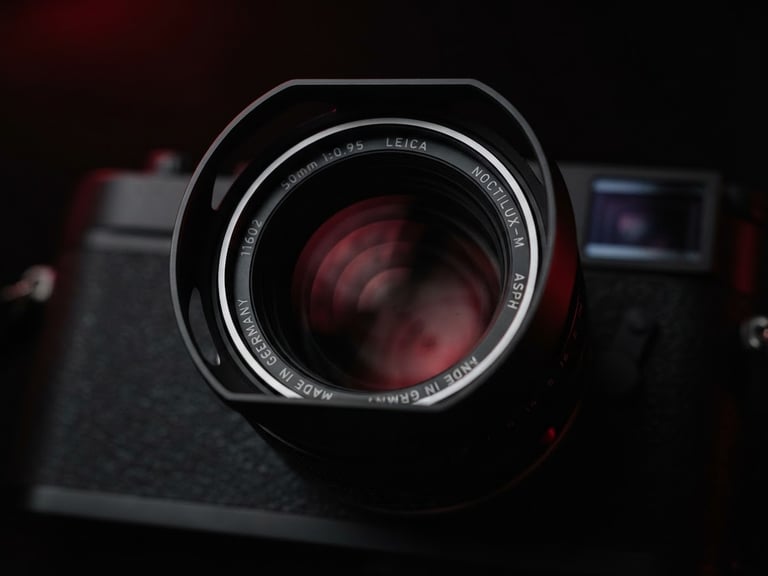 Cinematic macro shot of a high-end camera lens reflecting subtle crimson studio lights, dark obsidian background, ultra-premium editorial aesthetic