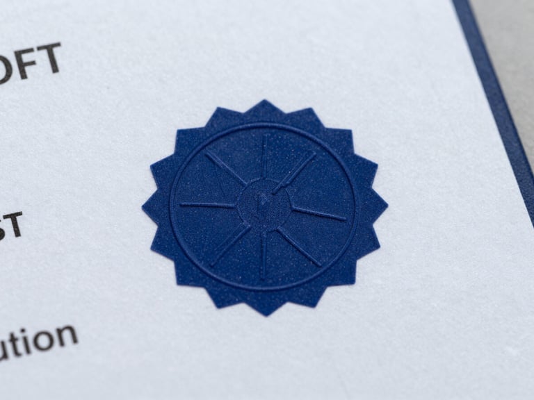 Macro studio shot of a physical skill certificate on heavy textured paper, crisp navy blue security seal in focus, clean neutral lighting