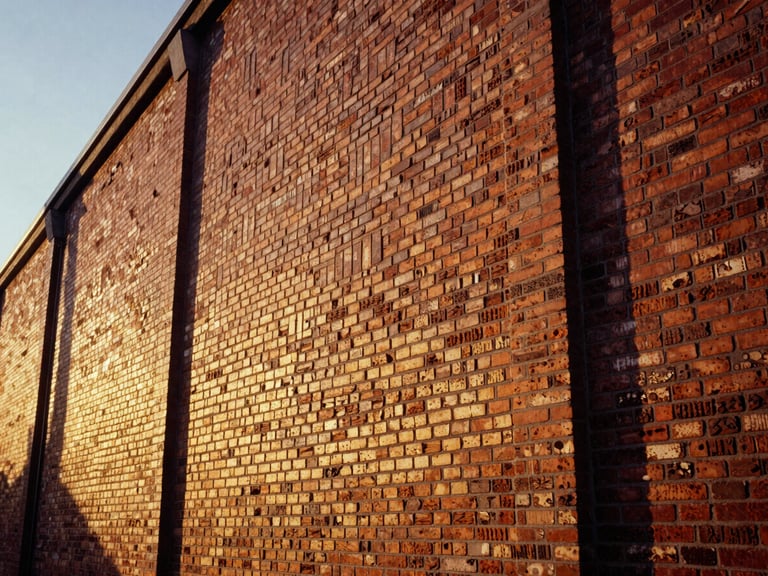 Close-up of restored hand-pressed brickwork on a coastal warehouse facade, low-angle golden hour light highlighting textures, medium format film.