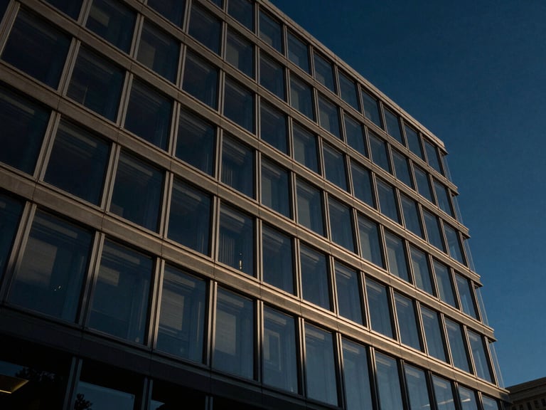 Low-angle dramatic architectural shot of a modern federal court glass facade reflecting a dark blue sky, sharp lines, 35mm