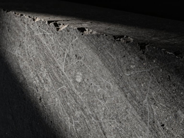 Extreme close-up of deeply veined raw travertine slab, dramatic side-lighting, deep shadows, 35mm lens.