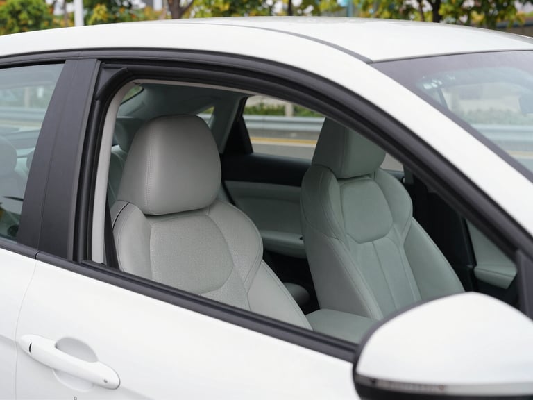 Clean white sedan car interior, comfortable seats, bright natural daylight, 35mm