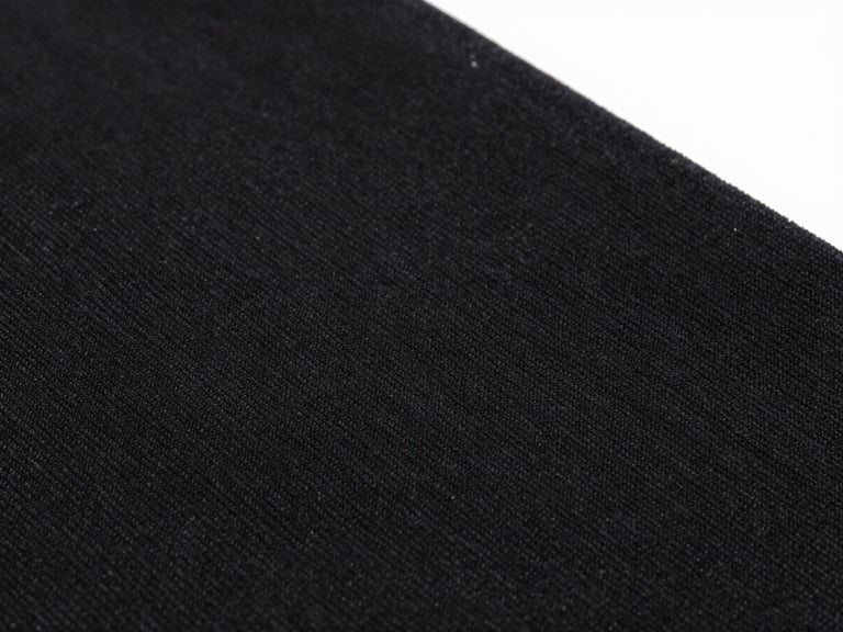 Macro close-up of high-fidelity DTF print on black cotton fabric, showing ink perfectly bonded to the textile fibers, bright studio product photography, sharp focus, 50mm