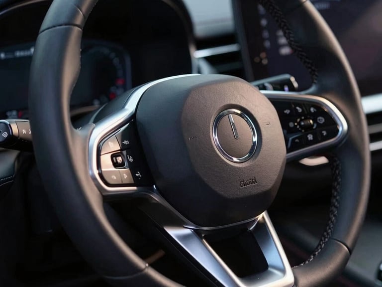 Dramatic low-key lighting close-up of a modern luxury vehicle steering wheel, silver metallic reflections, sharp focus, 35mm lens