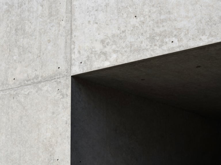 High-contrast architectural detail of concrete and deep shadows, minimalist design, sharp natural light, editorial framing.
