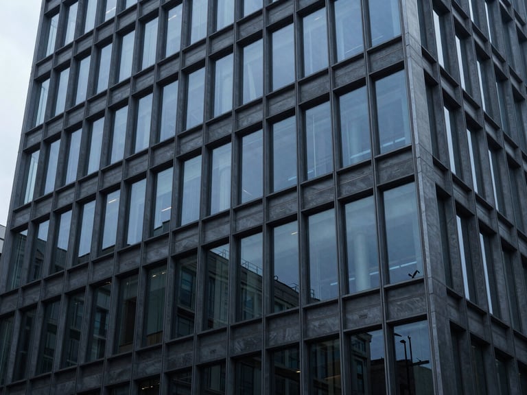 Geometric patterns of a modern office building facade reflecting a cool, overcast sky, deep blue and slate tones, architectural details, 35mm lens