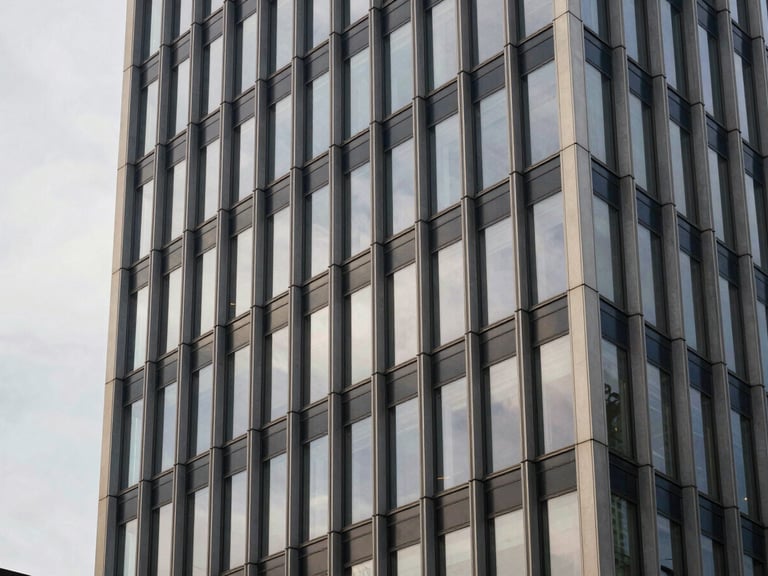 Modern architectural detail of a financial tower facade in Zurich, clean steel and glass lines reflecting a soft gray sky, editorial corporate photography