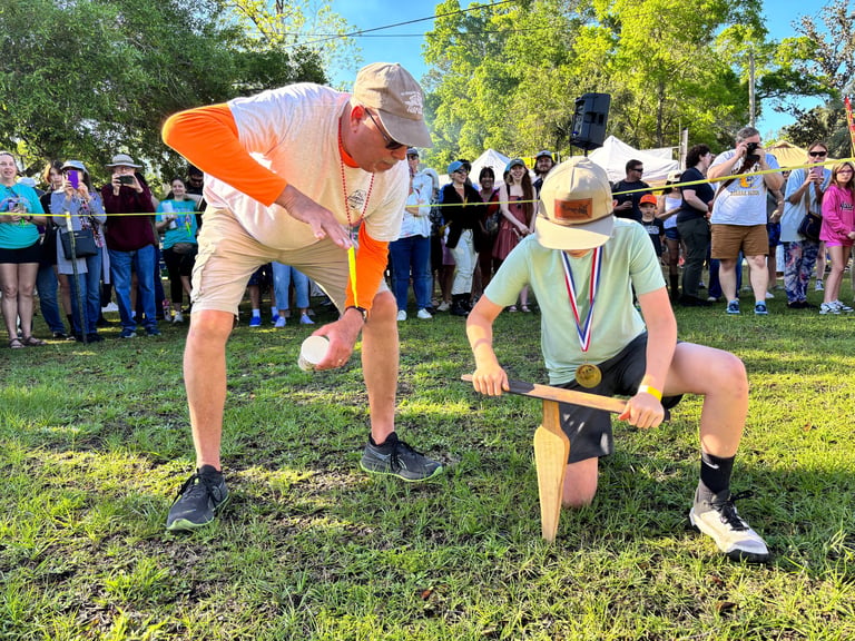 A man shows a young boy how to "grunt" for earthworms.