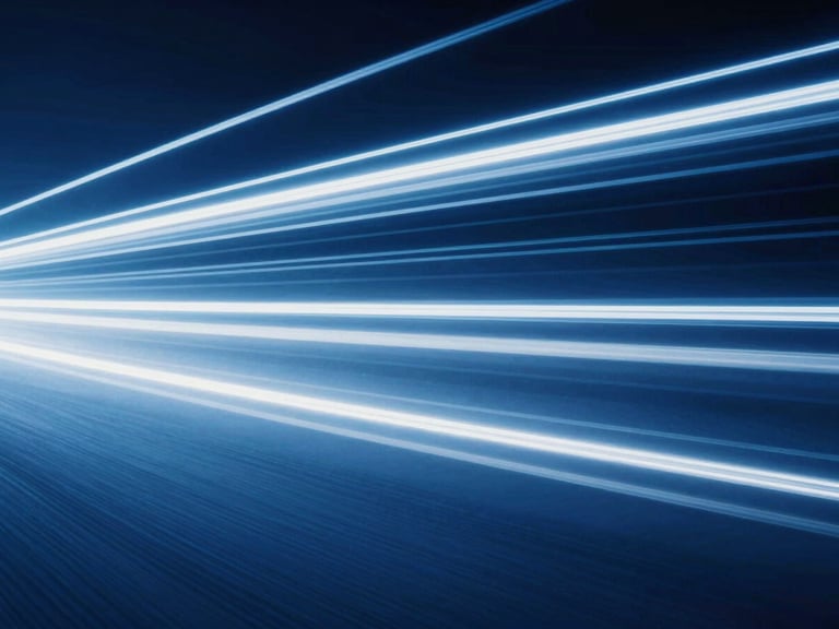 Abstract high-speed light trails in deep blue and white, streaking across a dark background, conveying digital momentum and velocity.
