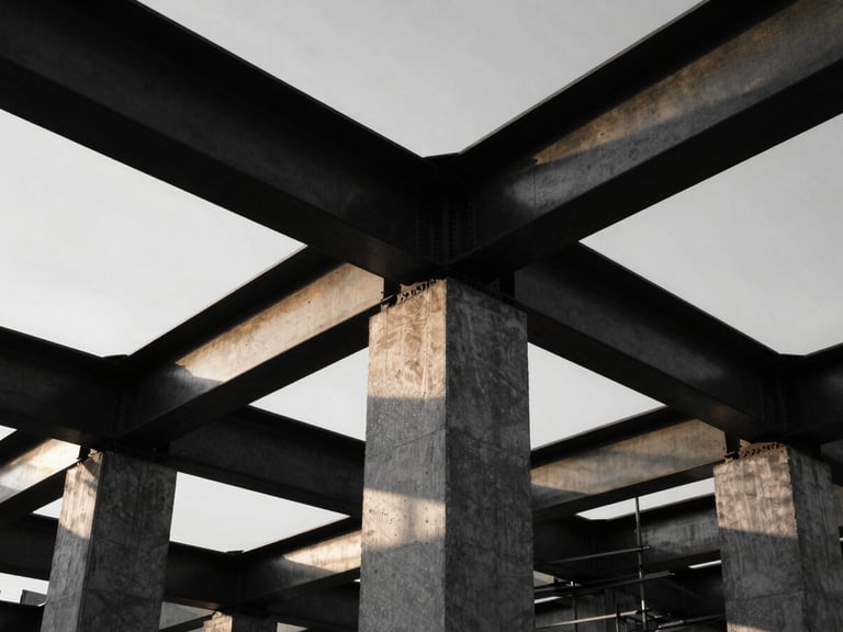 Close-up of a construction site, steel beams, concrete, high-contrast black and white, dramatic low-angle sunlight, architectural photography