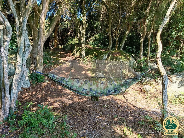 Rede de selva com tela mosquiteiro montada em meio à mata