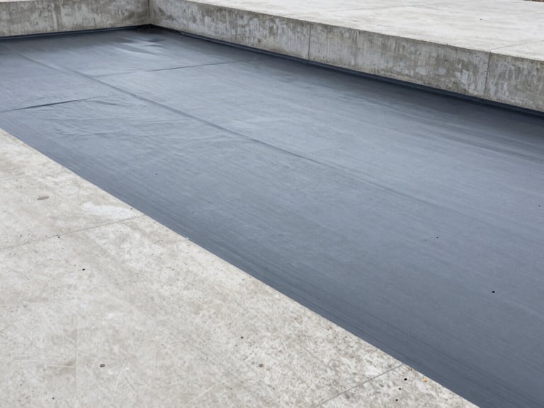 Architectural photography of industrial waterproofing membrane application on a concrete structure, cool concrete tones, sharp focus.