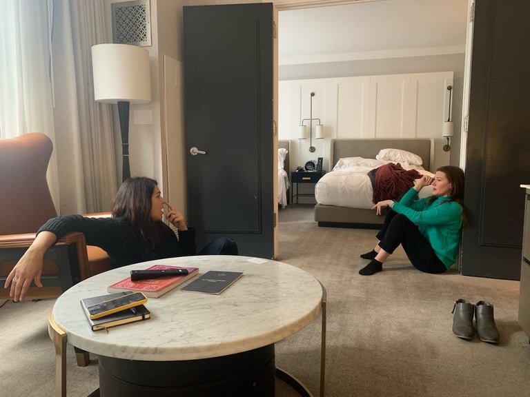 Image of two women talking seriously in a hotel room.