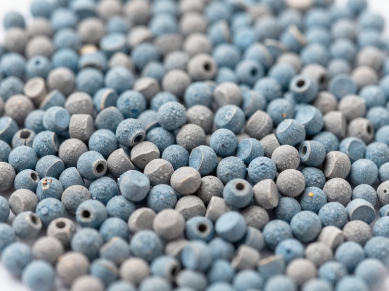 Macro shot of colorful masterbatch pellets in various hues, arranged precisely, bright neutral studio lighting, cool blue tones, sharp focus