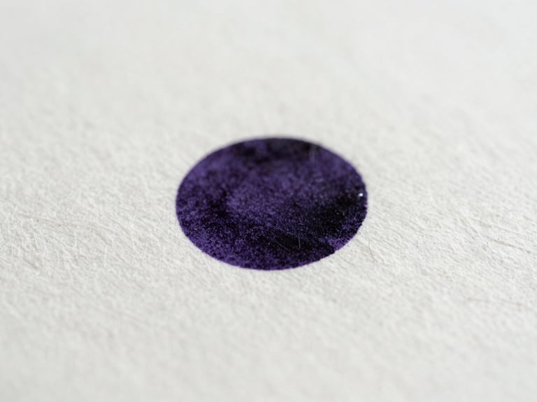 Macro close-up of dark violet ink drying on heavy textured cotton paper, soft natural side-light, fine paper fibers visible, minimalist composition