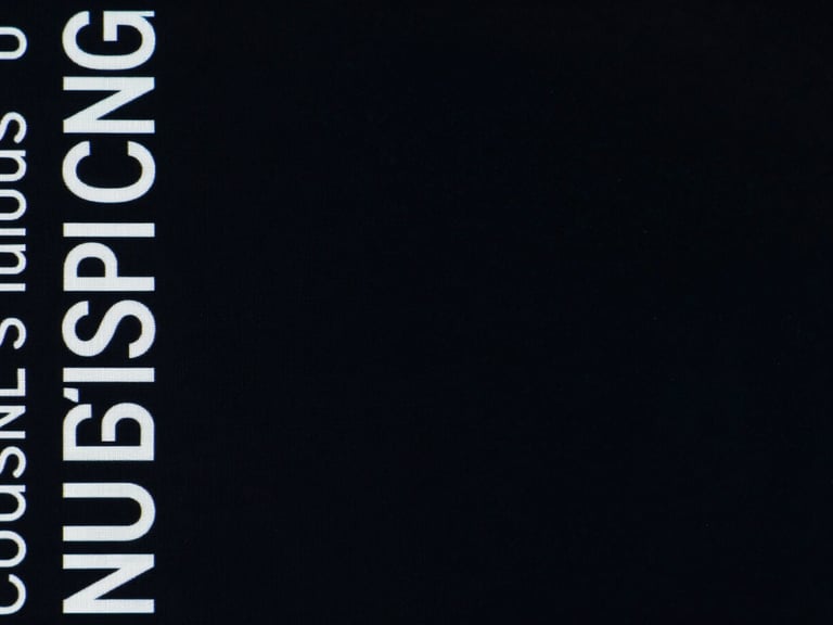 Wide panoramic 21:9 frame, extreme close-up of a high-contrast WebGL interface component, dramatic screen-glow against deep blacks, sharp typography visible on the left third, expansive negative space on the right.