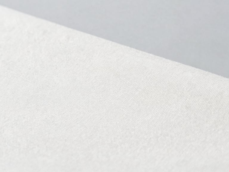 Close-up of premium organic cotton canvas fabric texture, clean weave, sharp focus, bright studio lighting, neutral gray backdrop